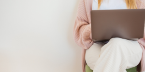 konsultacje psychologiczne online, pani w różowym swetrze z laptopem