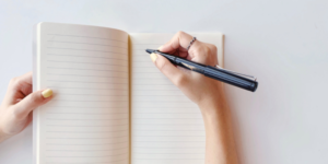 zeszyt, 2 ręce i ołówek do pisania